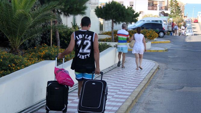 Turistas recién llegados se dirigen con sus maletas hacia uno de los establecimientos hoteleros de Mojácar.