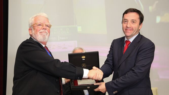 Ricardo Serra, presidente de Asaja Sevilla, entrega una placa al viceconsejero de Agricultura, Ricardo Domínguez.
