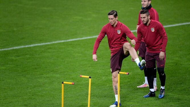 Fernando Torres realiza un ejercicio en el césped del Bayer Leverkusen mientras esperan Koke y Saúl Ñíguez.