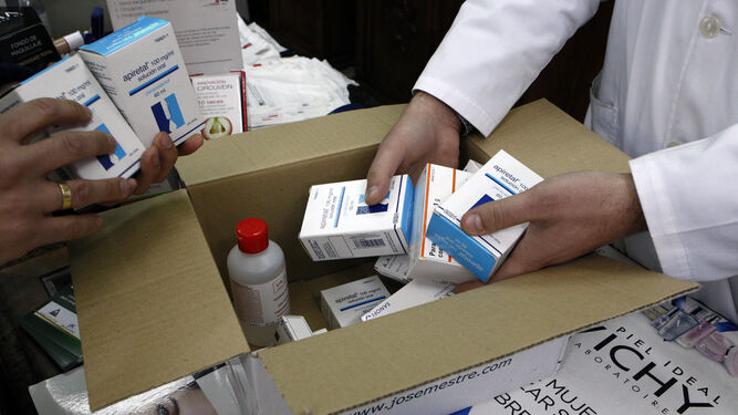 Farmacéuticos abren una de las cajas de pedidos de medicamentos.