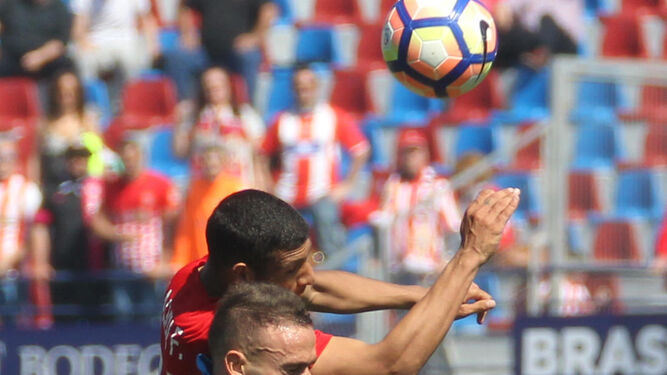 Joaquín Fernández disputa un balón por alto con el 'pichichi' Roger.