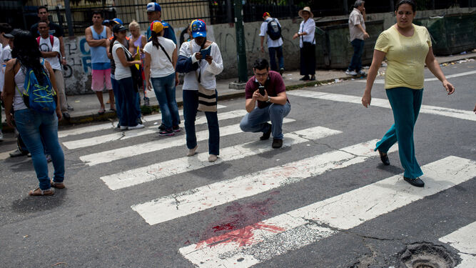 Vista de la mancha de sangre del joven que murió de un disparo durante una concentración de la oposición en Caracas.