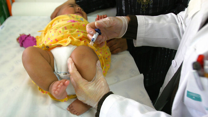 Un pediatra vacuna a un bebé en la consulta de Atención Primaria.