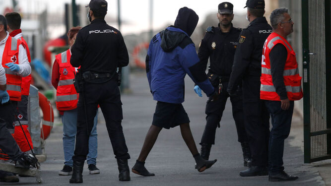 Varios agentes de Policía conducen a inmigrantes llegados al Puerto de la capital almeriense.