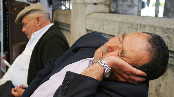 Un señor se duerme en un banco público ante la falta de descanso por la noche.