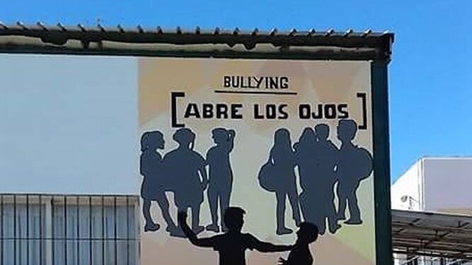 Estudiantes y responsables municipales frente al mural contra el acoso escolar.