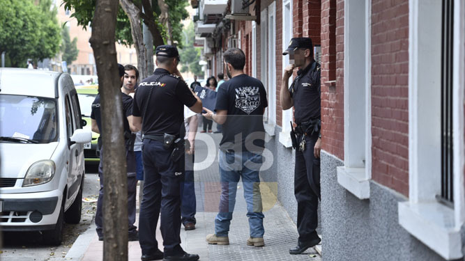 la Policía Nacional custodia la puerta del bloque de pisos donde ha tenido lugar el suceso.