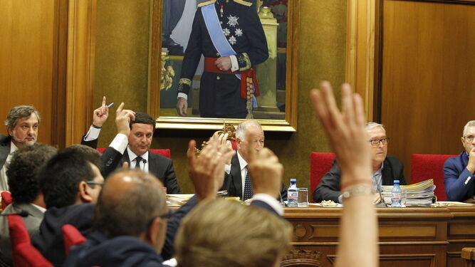 Los diputados populares alzan sus manos para votar a favor de la expulsión de Galasa de los cinco municipios que no han aceptado la tarifas.