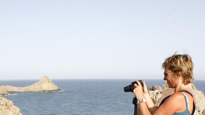 Una turista toma fotografías del Arrecife de las Sirenas de Cabo de Gata.