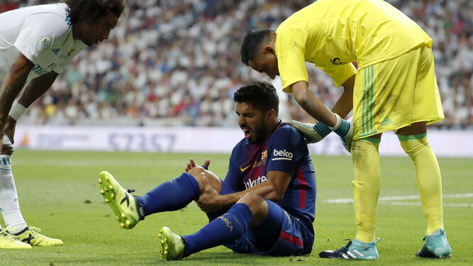 Luis Suárez se duele tras lesionarse en el Bernabéu.