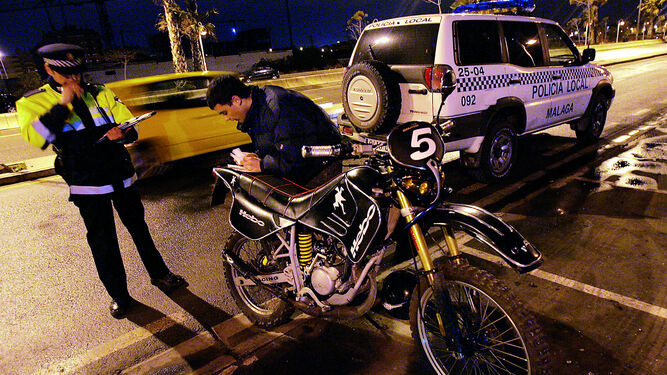 Un policía multa a un joven por conducir una moto trucada con exceso de contaminación acústica